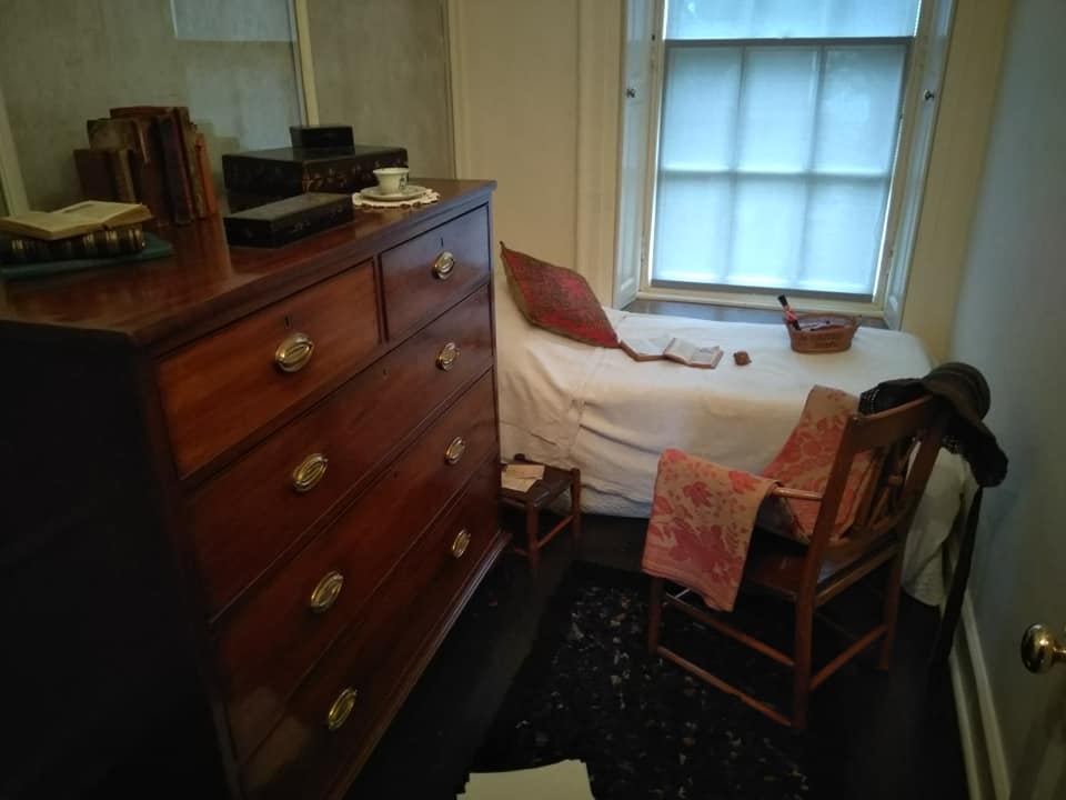 The children's nursery, with a wooden chest of drawers and rocking chair, and a small bed